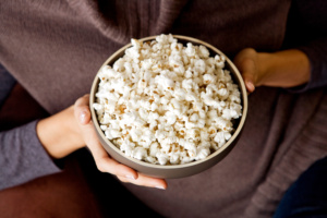 A woman holding a bowl of popcorn.
